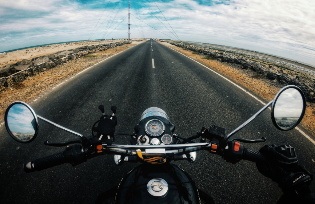 Pessoa realizando viagem de moto em uma estrada.