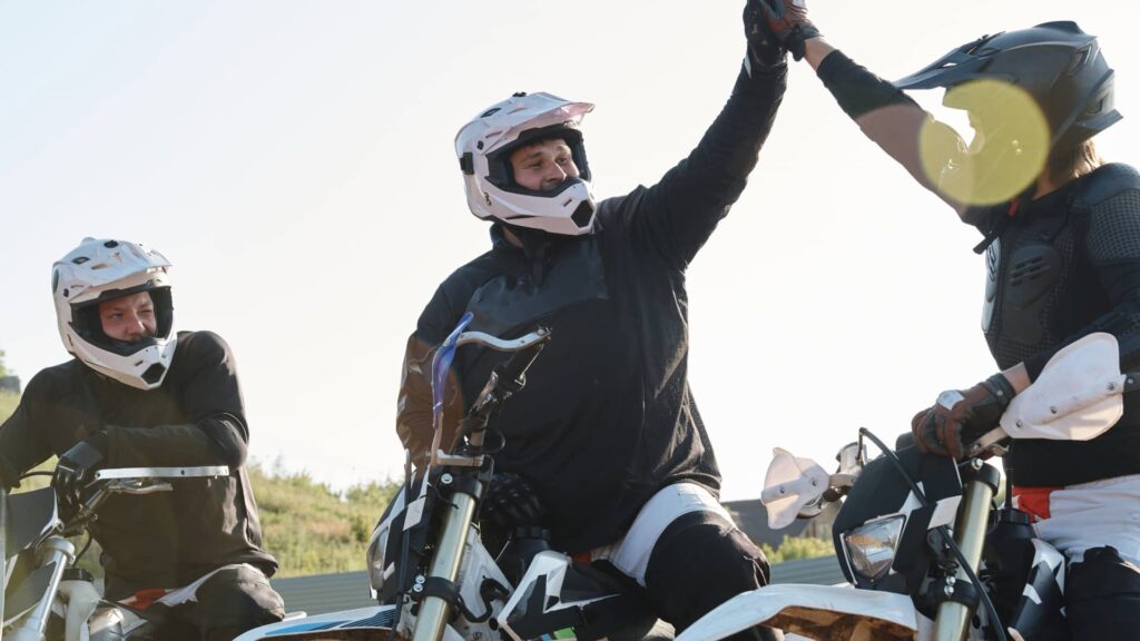Grupo de 3 amigos comemorando por estarem em evento de motos.